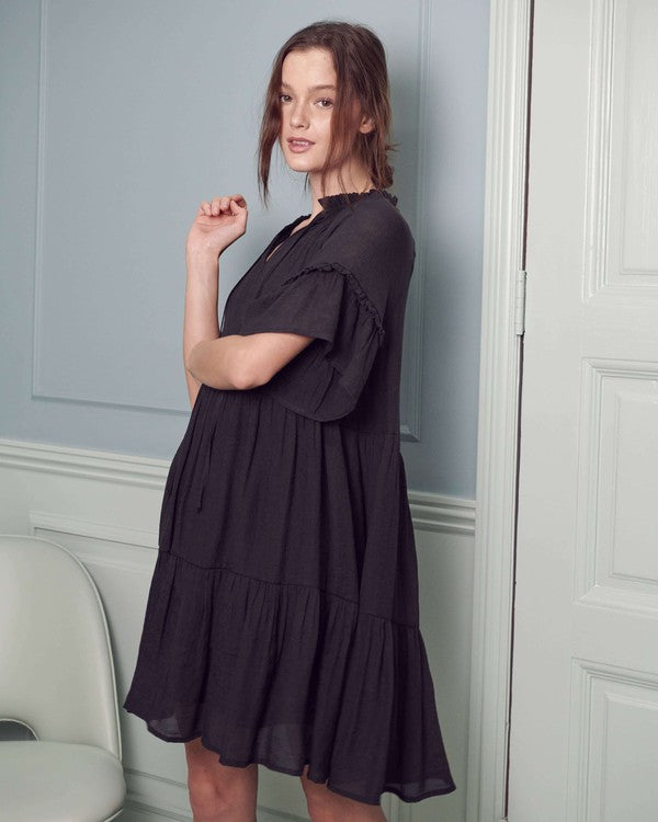 Elegant black tiered dress with a V-neckline and ruffled accents.