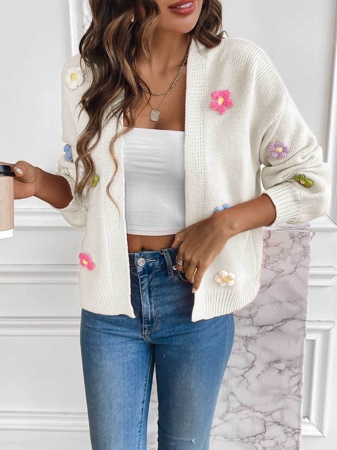 White cardigan with pink, yellow, purple, and blue flowers.