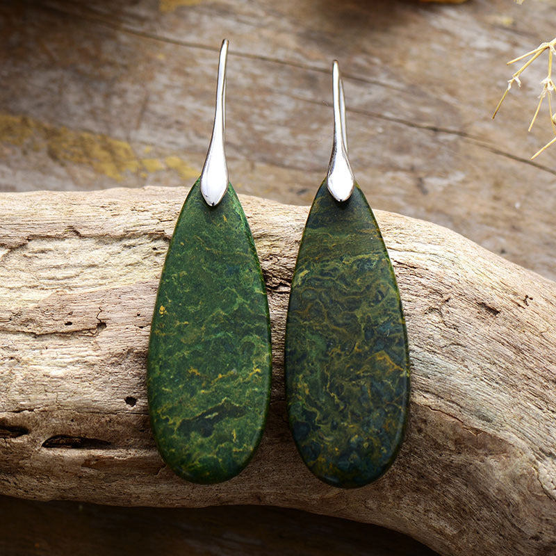 Green teardrop earrings featuring a unique stone pattern and silver hooks.