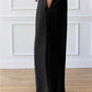 Black wide-leg lounge pants with a stretchy waistband and drawstring.