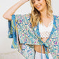 Turquoise kimono with flowy fit and floral details.