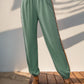 Stylish sage green joggers with elastic waist and colorful side detail.