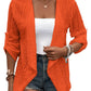 Versatile orange cardigan with roll-up sleeves.