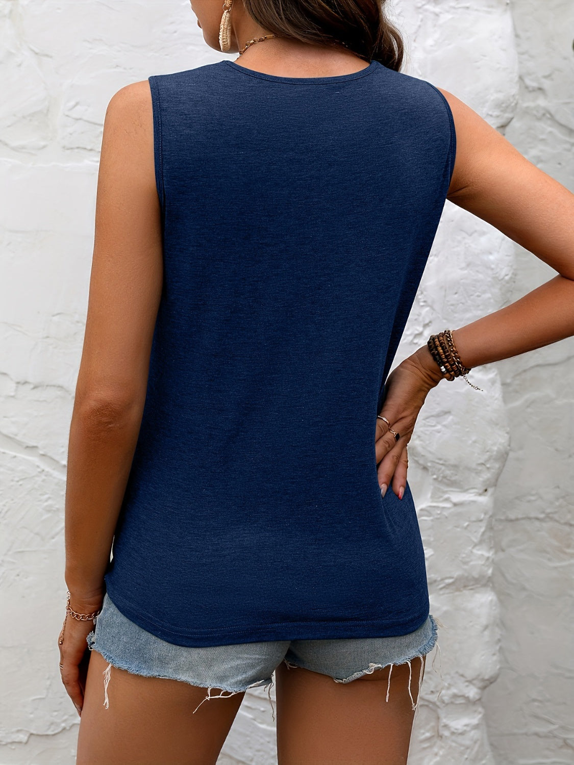 Stylish dark blue sleeveless top with delicate black lace neckline, paired with distressed denim shorts for a chic summer look