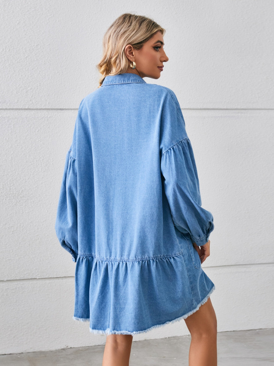 Chic denim dress with a trendy raw hem, comfy fit, button-up front, and handy pockets—perfect for a casual yet stylish look.