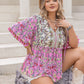Flowy pink top with colorful floral designs and V-neckline