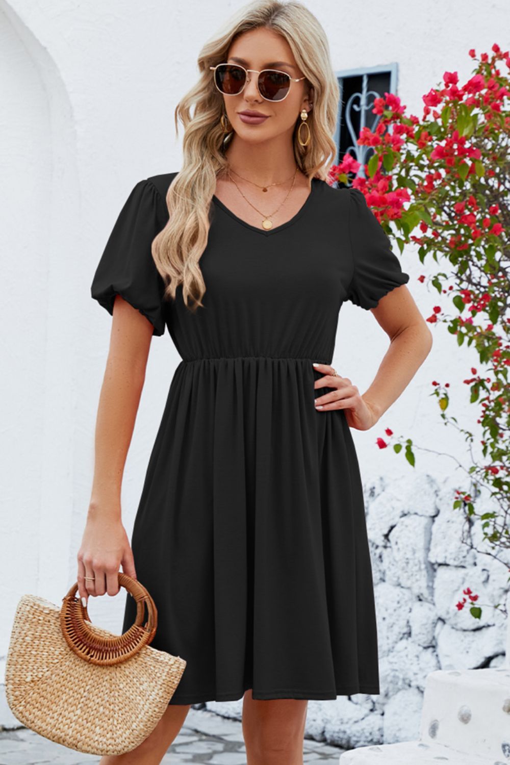 Black knee-length dress with puff sleeves and a gathered waist.