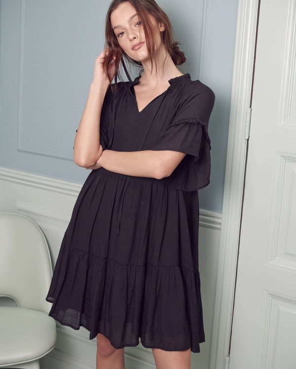 Casual black boho dress with a tiered design and ruffled sleeves.