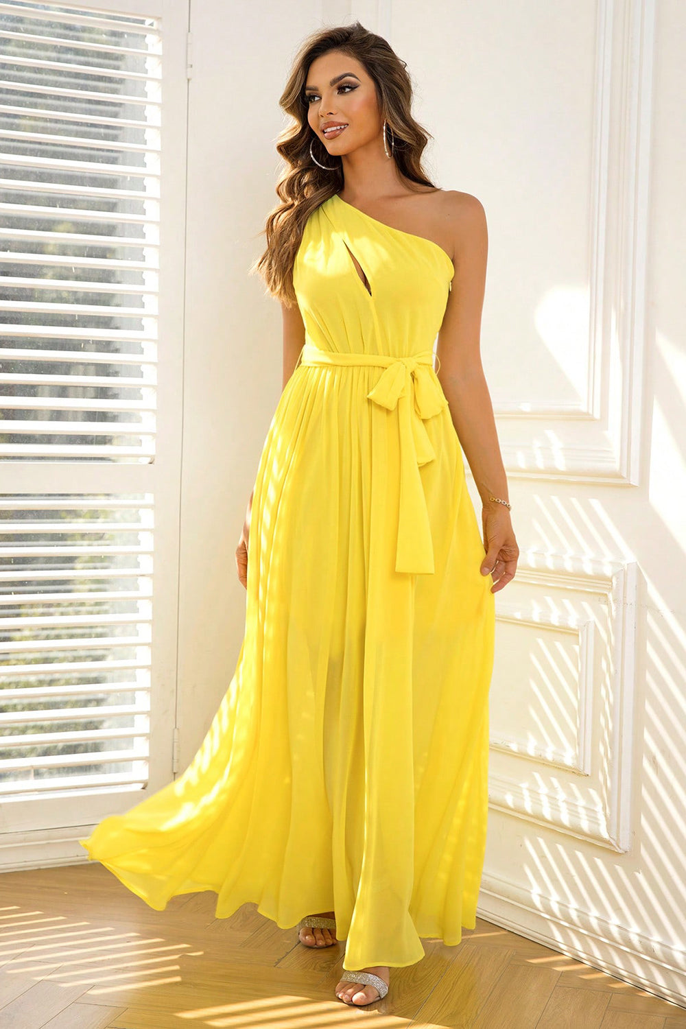 Full-length yellow gown with a single shoulder strap and a delicate waist tie