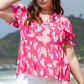 Model posing in a vibrant pink camo top with ruffle sleeves