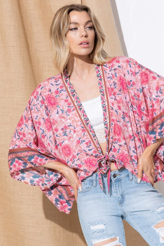 Pink kimono with floral print and lightweight material.