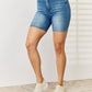 Elevate your summer wardrobe with Judy Blue's Double Button Bermuda Denim Shorts, offering tummy control for a sleek look and ultimate comfort.