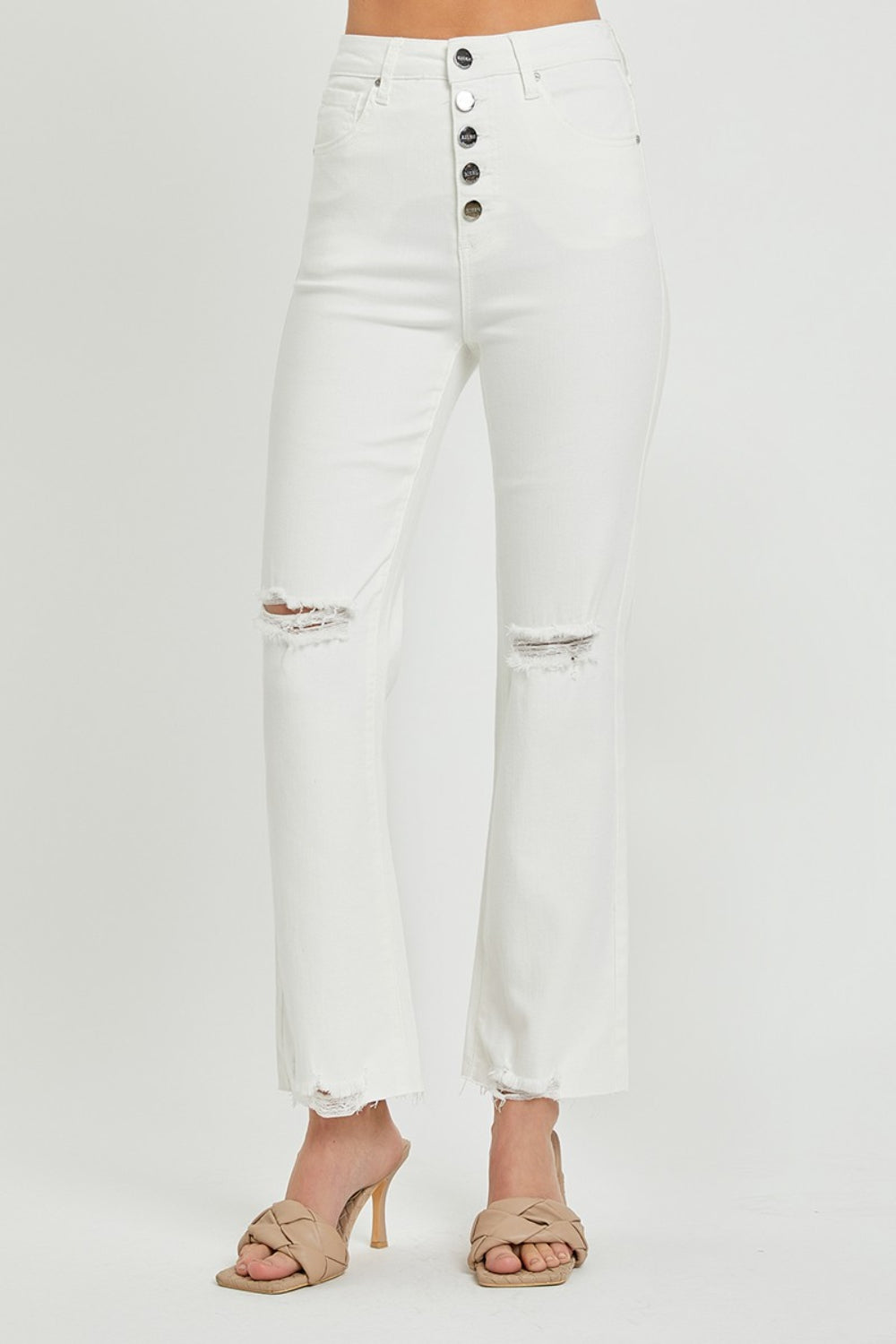 Distressed white jeans with a high waist and button fly design.