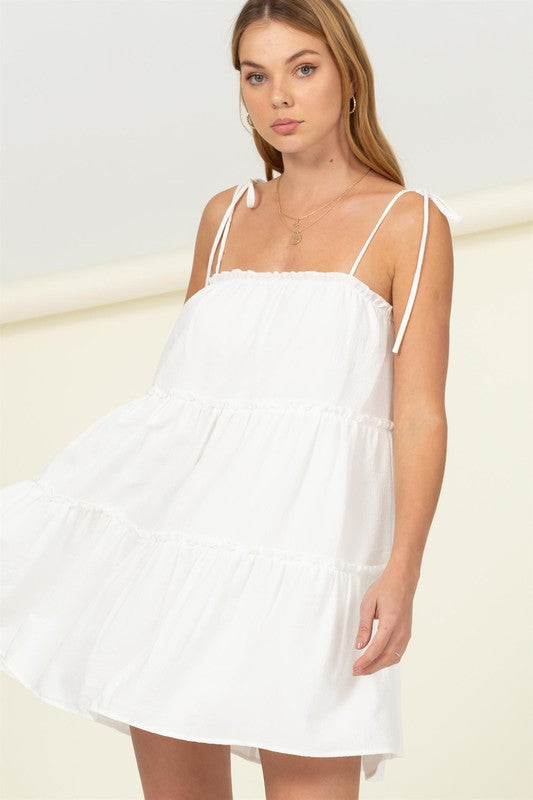 White summer dress featuring tiered ruffles and tie straps