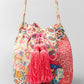 Pink and cream patterned bucket bag with drawstring closure and tassels.