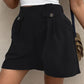 Chic black shorts with decorative buttons and pockets, perfect for versatile summer style and comfort.