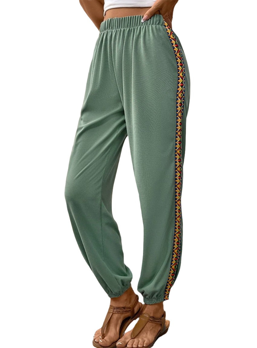 Sage green jogger pants with colorful embroidered side stripe.