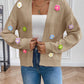 Tan cardigan with colorful knitted flower accents.