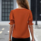 Trendy orange blouse with notched collar and ruffled sleeve details