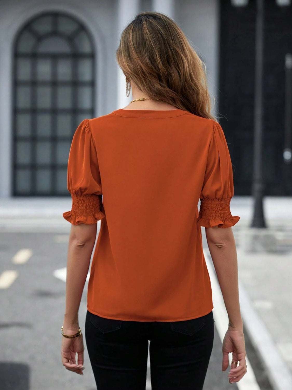 Trendy orange blouse with notched collar and ruffled sleeve details