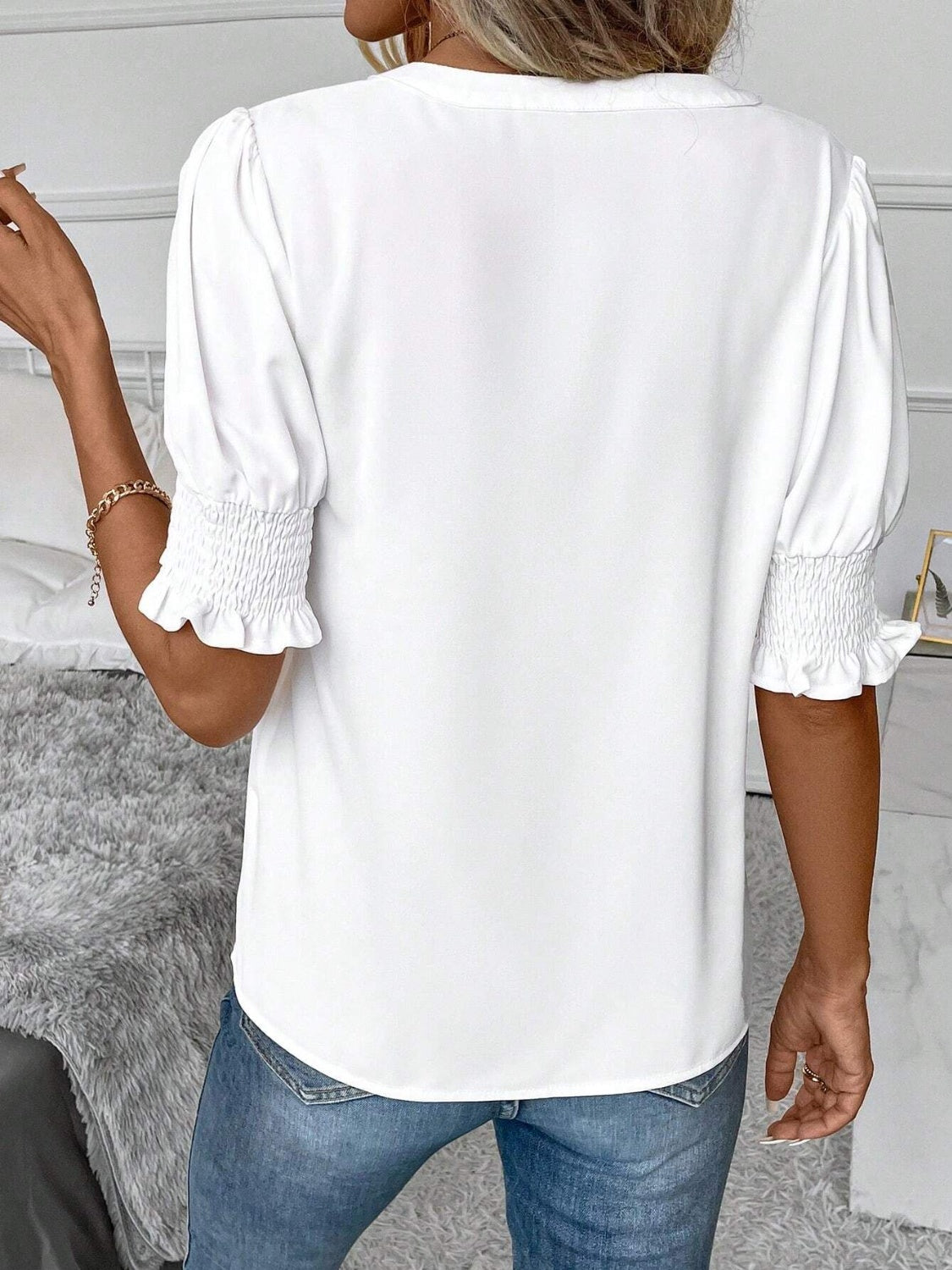 Classic white blouse with notched neck and ruffle accents on sleeves
