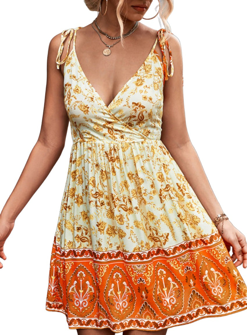 Close-up of the vibrant boho orange and yellow floral pattern on a summer dress.