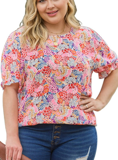 Woman smiling in a vibrant Southern Charm Floral Blouse, showcasing the bright and colorful floral print
