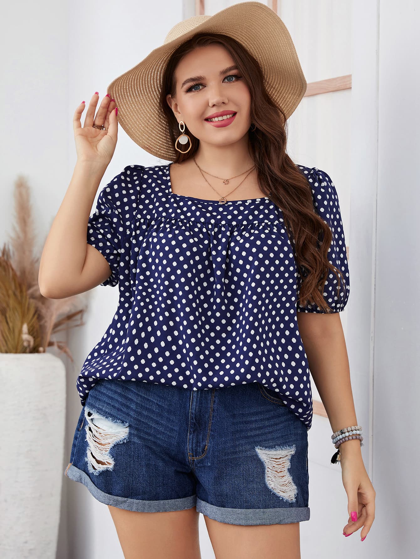 Southern-inspired navy blue polka dot blouse paired with denim shorts, showcasing a chic and comfortable look