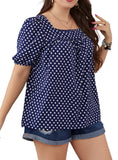 Woman wearing a navy blue polka dot blouse with short sleeves and a relaxed fit, perfect for casual summer outings