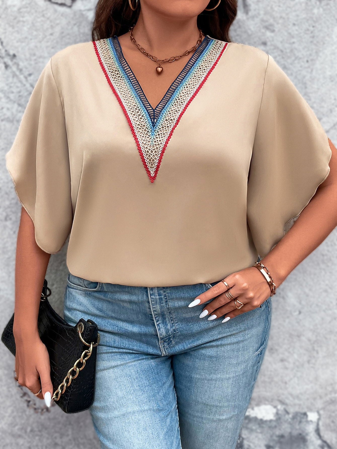 Versatile plus size blouse with beautiful red, blue, and white embroidery, paired with a black handbag