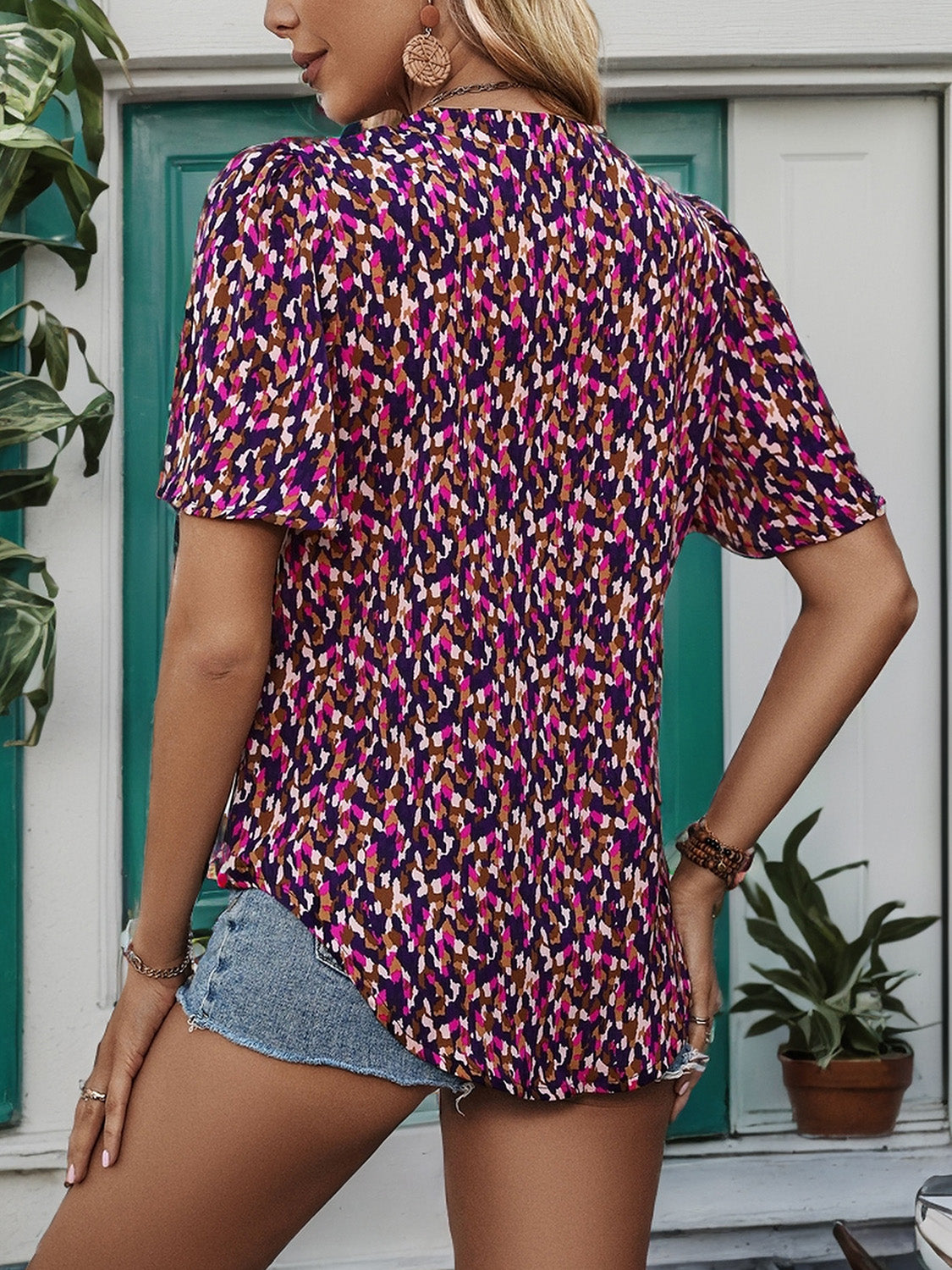 Lightweight, vibrant patterned blouse perfect for Southern fashion, styled with a woven belt and denim jeans