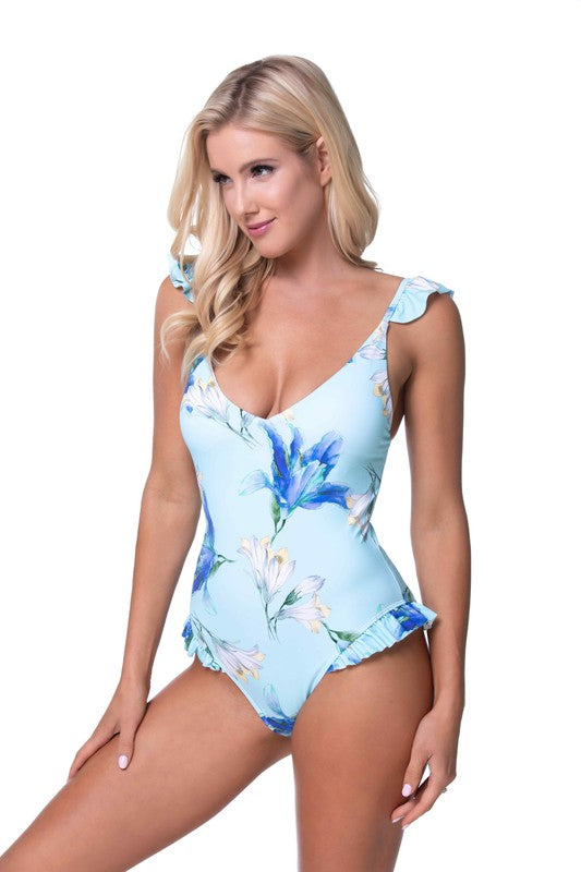 Model posing in a high-cut floral swimsuit with ruffle shoulders, highlighting the flattering fit.