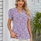 Short-sleeved blouse with purple floral design and notched collar