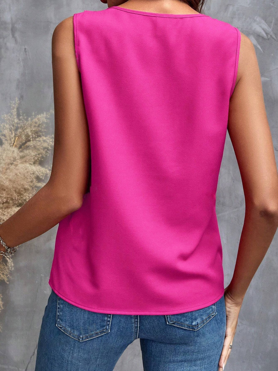 Woman in a chic pink ruffle sleeveless top, perfect for casual and stylish summer looks