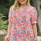 Detailed view of the beautiful floral design on a summer-ready, versatile women's top