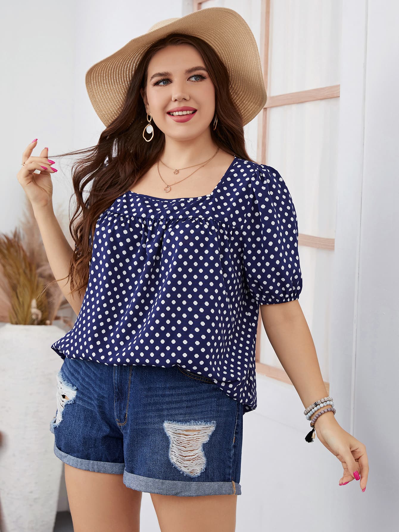 Navy polka dot blouse with white spots, styled with gold hoop earrings for a touch of elegance