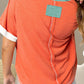 Orange V-neck tee with aqua neckline and white sleeve cuffs.