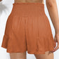Chic terracotta high-rise shorts with a flattering smocked waistband and tie-front. Perfect for a stylish, comfy summer look.