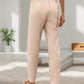 Breathable beige drawstring pants with a relaxed fit and stylish design.