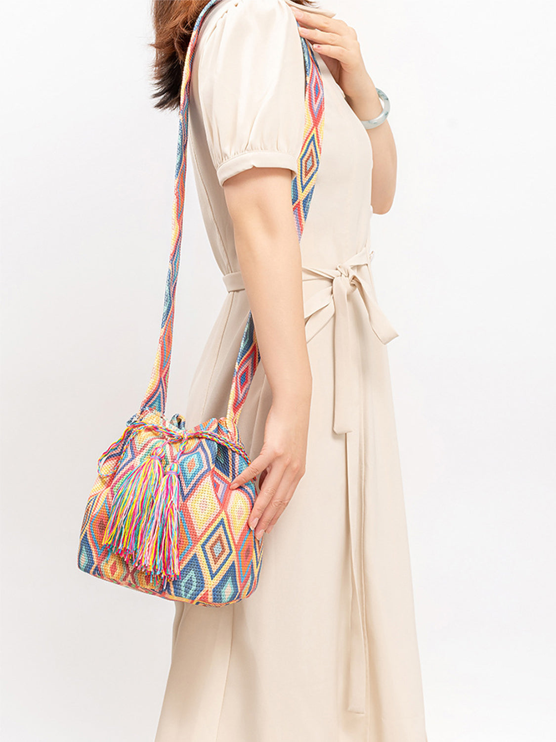Woven fabric bucket bag with colorful geometric designs.