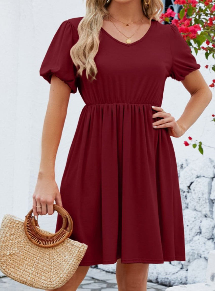 Wine V-neck dress with puff sleeves and a flared skirt.