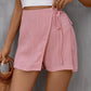 Chic pink high-waist skort with a flattering tie feature, blending elegance with comfort for everyday wear.