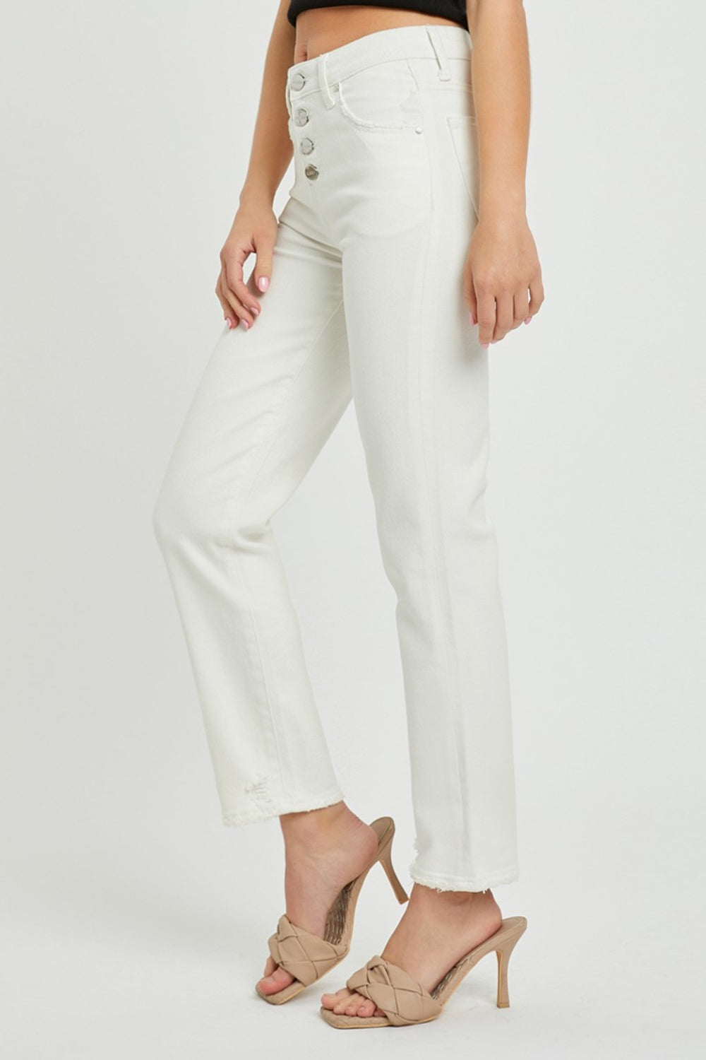 White mid-rise jeans designed with a classic button-fly front from RISEN.