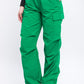 Close-up of green cargo pants showing functional side pockets and ankle fastenings.
