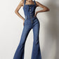 Retro-inspired dark wash overalls styled with sleek boots for a modern touch.
