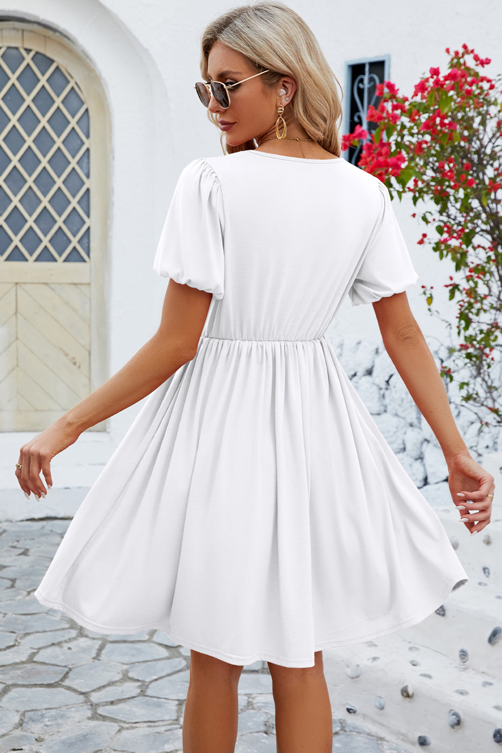 White V-neck dress with puff sleeves and a flared skirt.