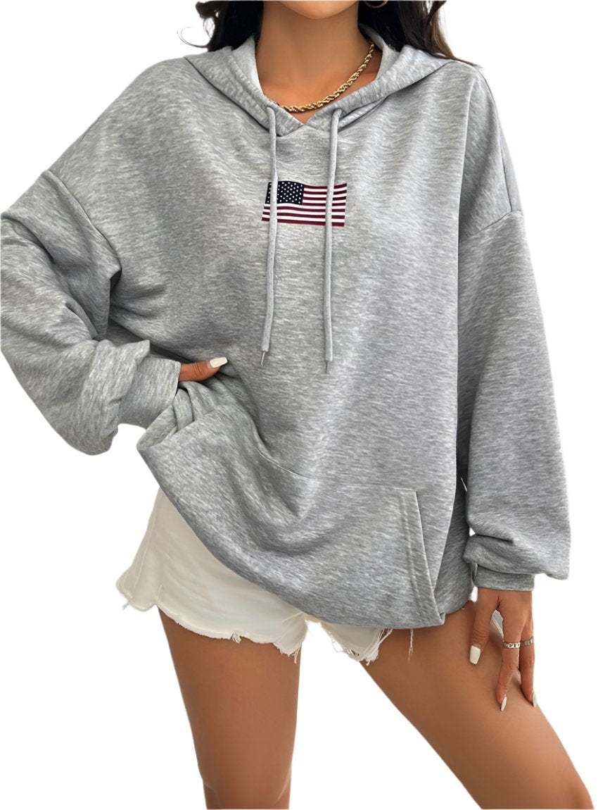 Woman wearing a gray hoodie with an embroidered American flag on the chest.
