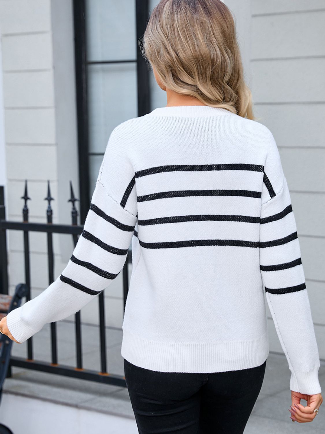 Back view of black Angel Wings sweater with bold white stripes and bow detail
