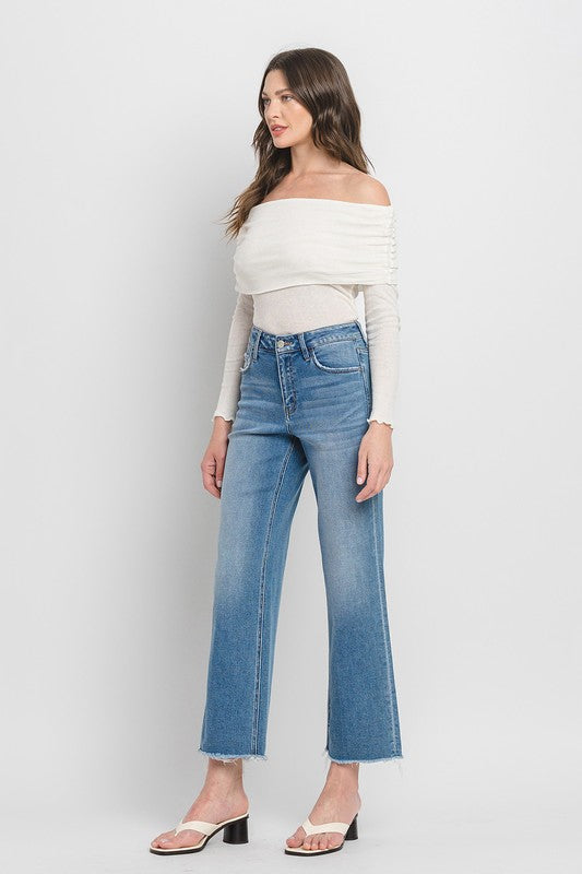 Woman wearing high-rise ankle slim wide-leg jeans with heels.
