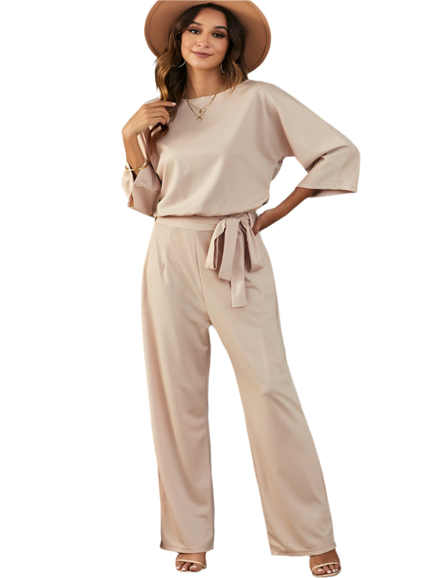 Front view of an apricot boat neck wide-leg jumpsuit featuring a waist tie.
